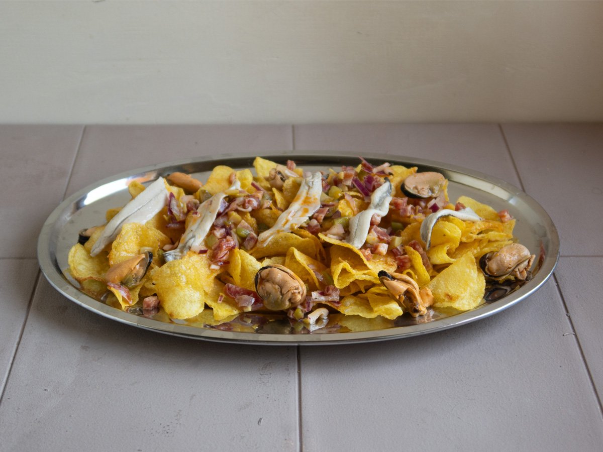 Aperitivo casero de patatas con mejillones en conserva y boquerones